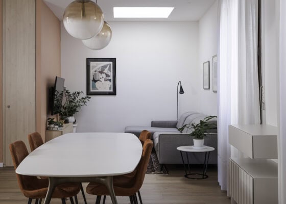 Zona pranzo con tavolo ovale e salotto integrato nella stessa zona giorno open space